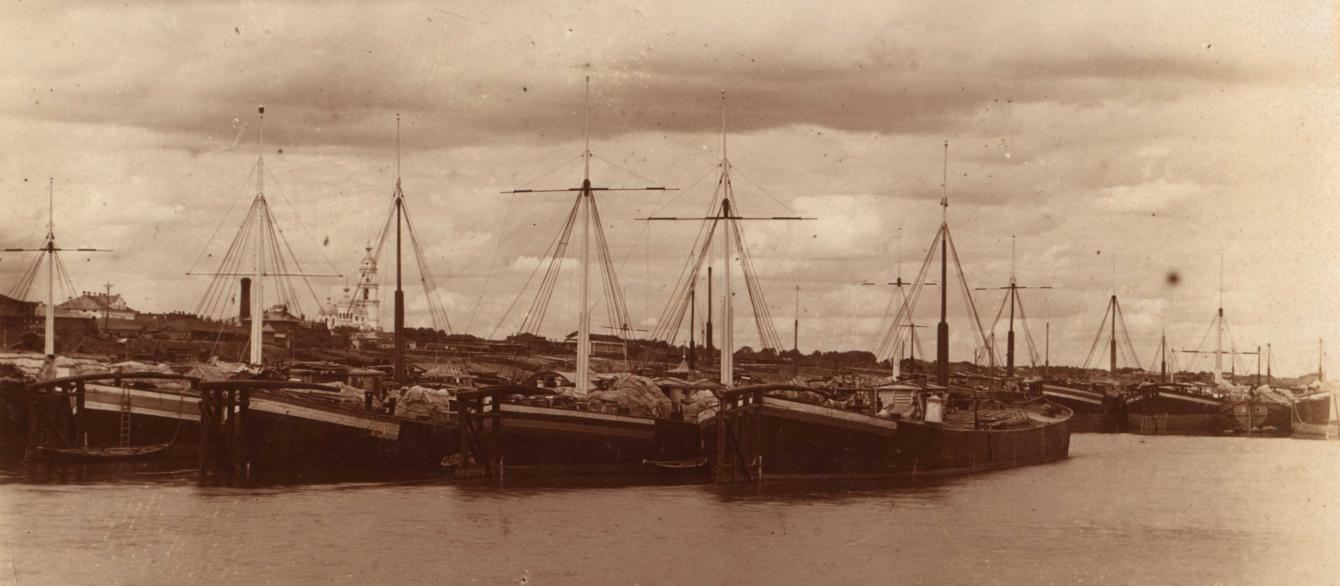 Sepia image of ships loaded with grain