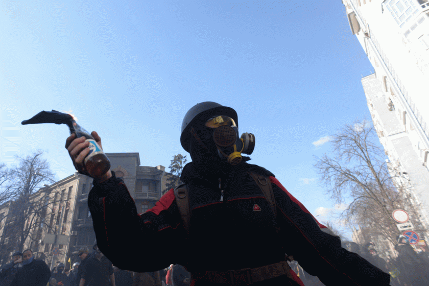 masked protestor with Molotov cocktail