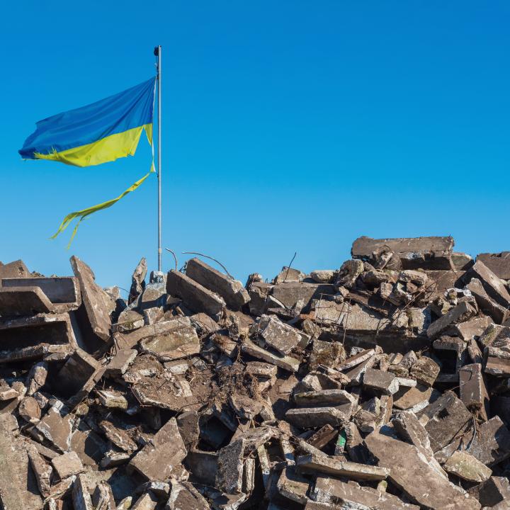  Destroyed Ukrainian building and damaged flag in the wind.