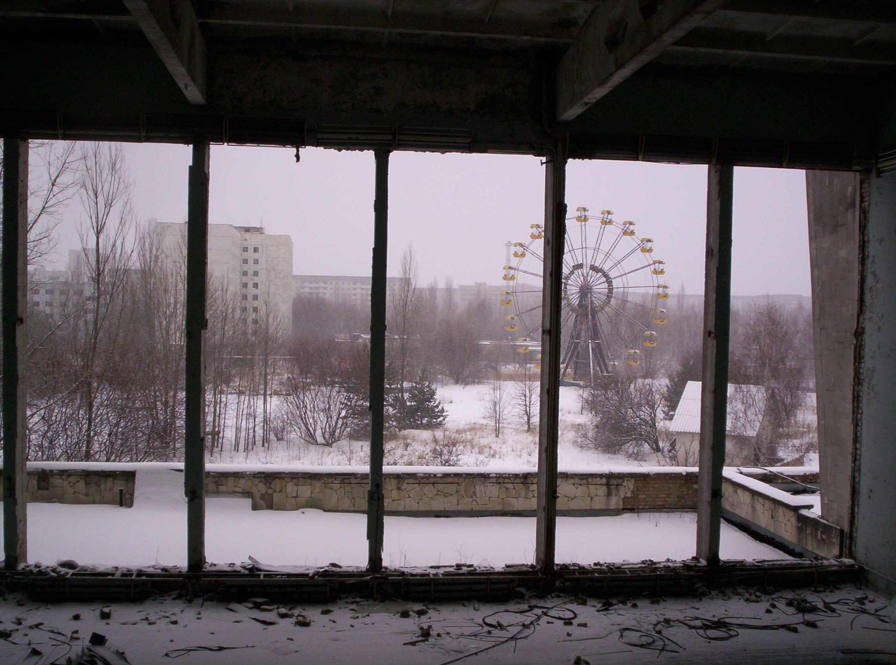 ferris wheel seen through windows of abandoned building