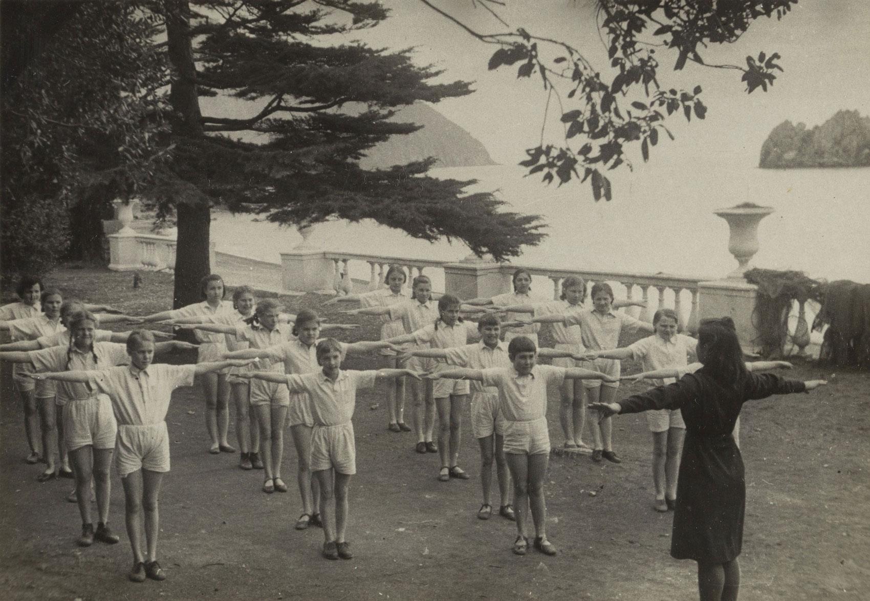 A group of children and instructor perform exercises at the Artek Pioneer Camp.