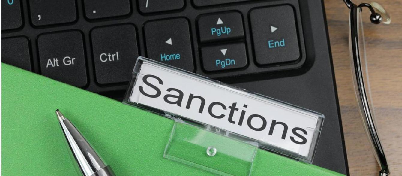 Folder labeled "sanctions" resting against keyboard