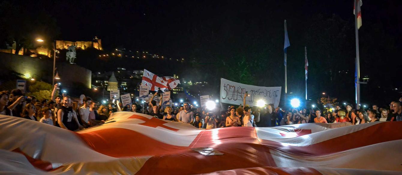 Nighttime protest with Georgian flags