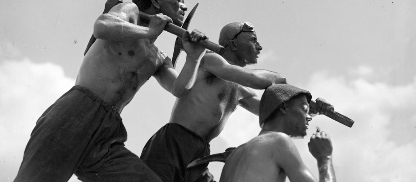 Three workers hold pick axes in a still from Salt for Svanetia