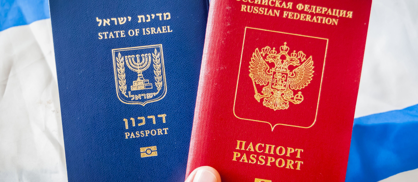 Hand holding Russian Federation and State of Israel passports