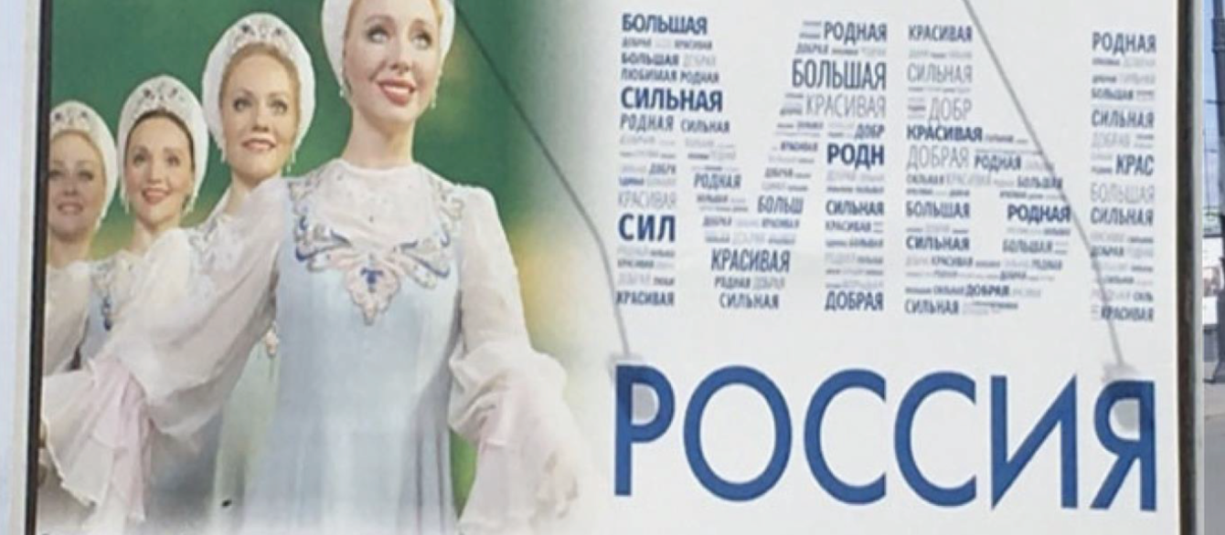 A Russian billboard featuring four women wearing dresses and bonnets.