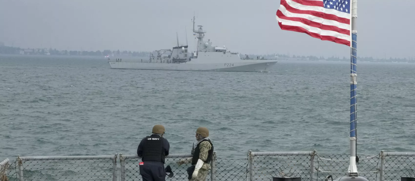 Members of the U.S. Navy of the Arleigh Burke-class guided-missile destroyer USS Ross look on Britain's Royal Navy patrol ship OPV "Trent" in Sea Breeze 2021 maneuvers in the Black Sea, July 7, 2021.