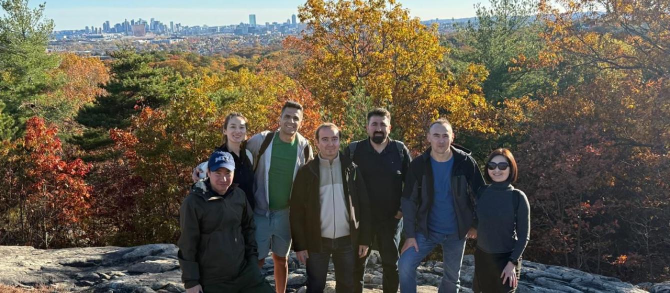 group of hikers with fall foliage and Boston skyline in background