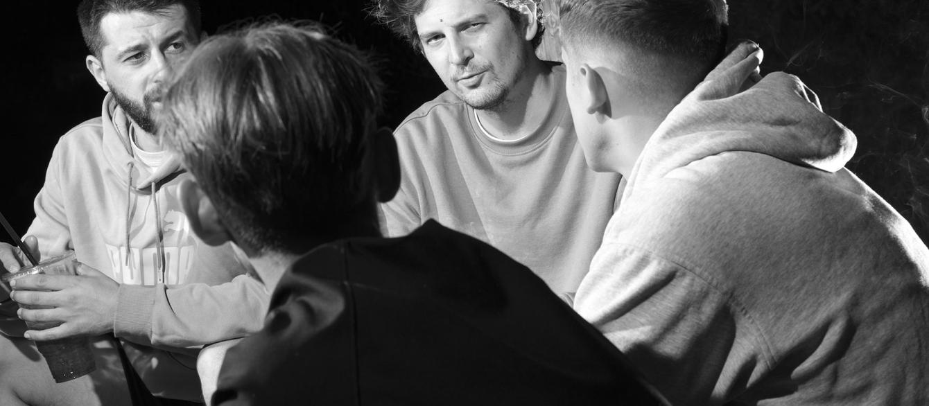group of men sitting; black an white photo
