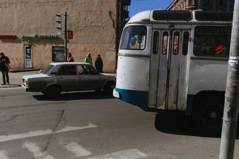 post-Soviet street with bus, car, and people