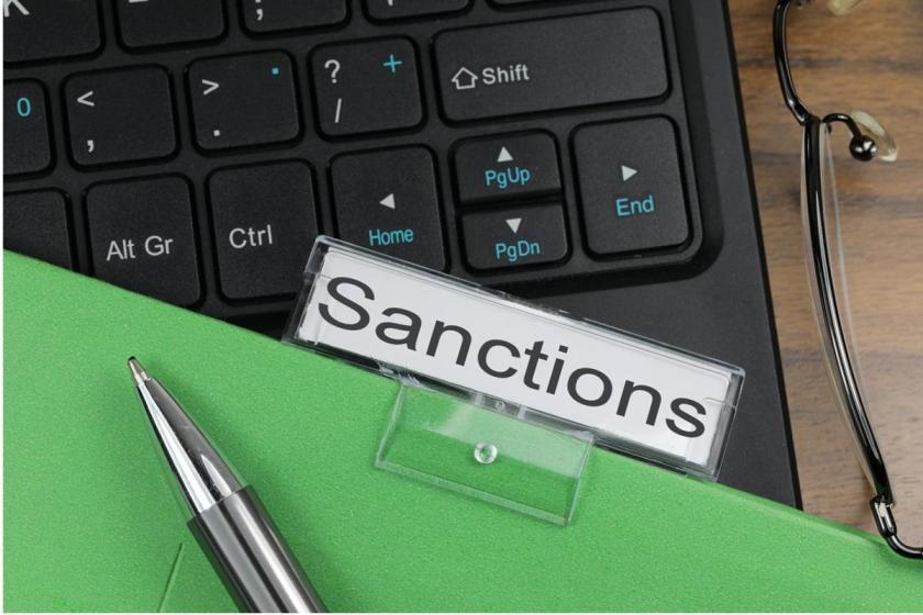 Folder labeled "sanctions" resting against keyboard