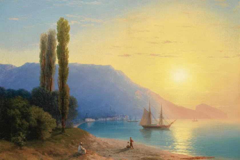 sunset over water with figures on the beach