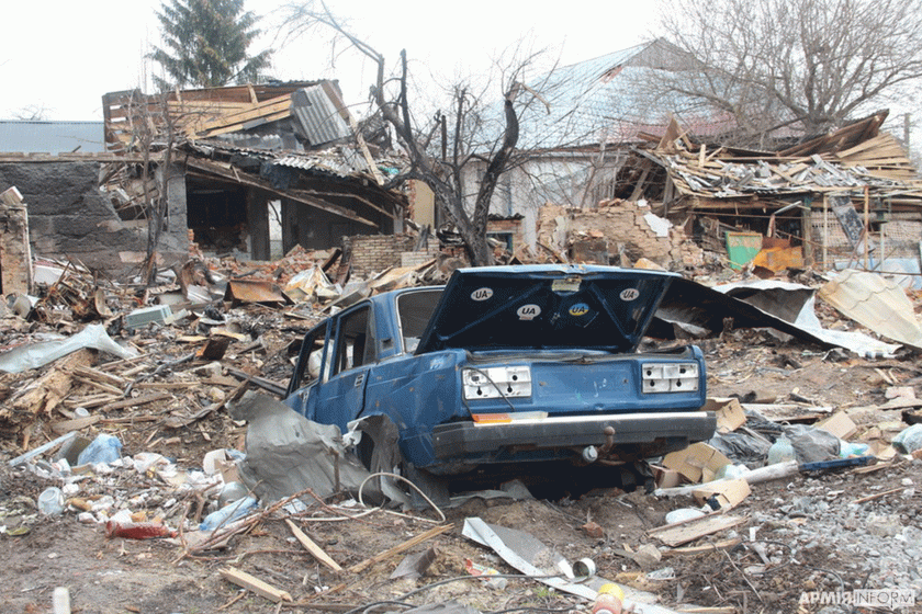blue car in a rubble after bombing in Ukraine