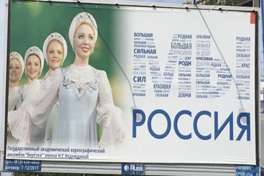 A Russian billboard featuring four women wearing dresses and bonnets.