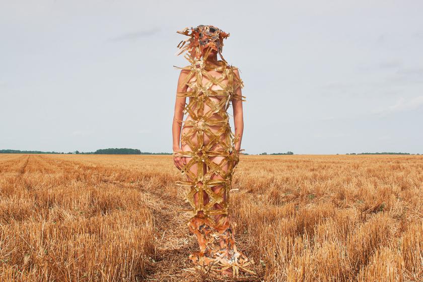 a woman dressed in paper textiles in the field of hay