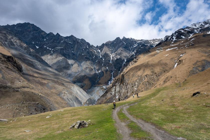 Hikers enjoy the spectacular view of the Greater Caucasus Mountains. Stepantsminda, the Republic of Georgia.