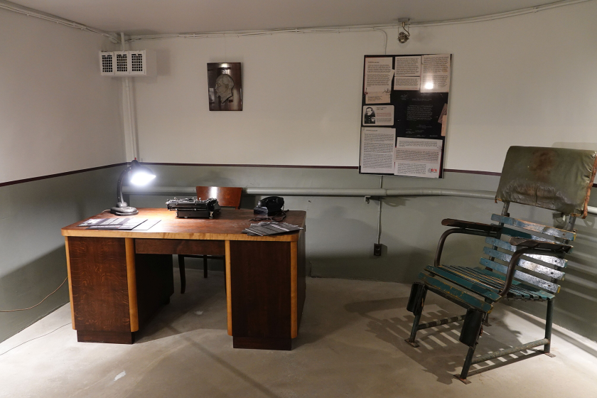 interrogation room with a chair, desk, and a portrait of Lenin on the wall