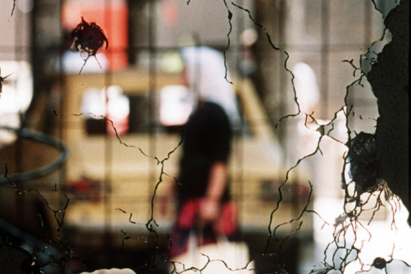 a cracked mirrot by the bullet reflecting a women and a car