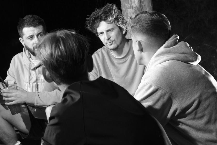 group of men sitting; black an white photo
